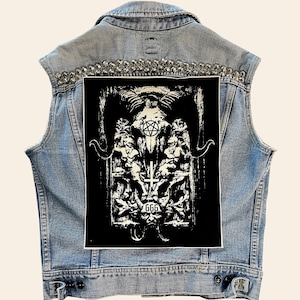 May include: A black denim vest with silver studs and a black and white patch featuring a skull with a pentagram, a cross, and the number 666.