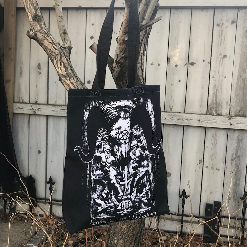May include: Black tote bag with a white graphic print of a horned figure with a pentagram and the number 666. The text "Loais" and "Magnon" are printed at the bottom of the bag.