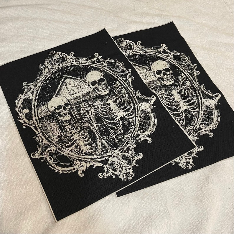 May include: Two skeletons in a spooky, ornate frame with a house in the background. The image is in black and white and has a distressed look.