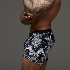 May include: Black and white underwear with a graphic print of a horned creature. The underwear has a black waistband.