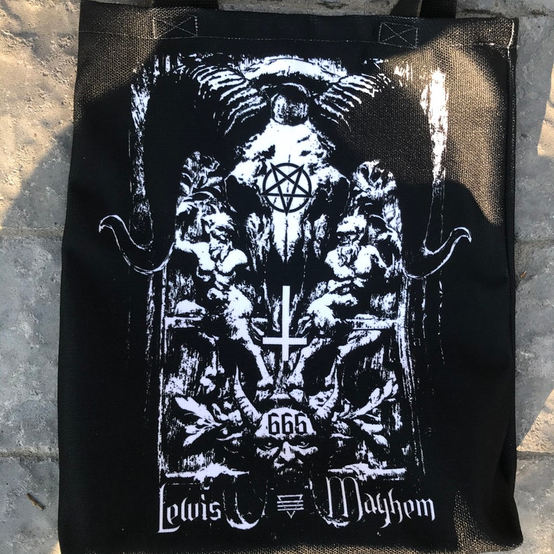 May include: Black tote bag with a white graphic print of a skull with horns, a pentagram, and a cross. The text "Lewis  Mayhem" and "666" are also printed on the bag.