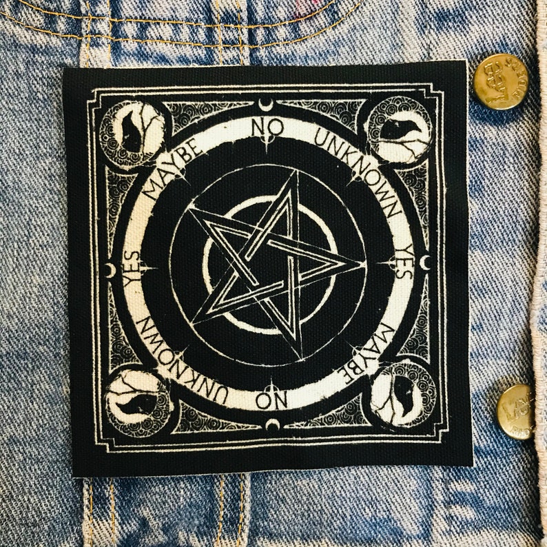 May include: Black and white square patch with a pentagram design at the center. The patch has the words "YES", "NO", "MAYBE", and "UNKNOWN" around the edges. Decorative elements and crescent moons are also present.