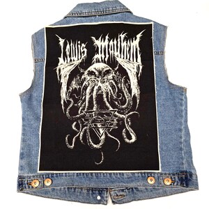 May include: A denim vest with a black patch sewn on the back. The patch features a white graphic of a creature with wings and tentacles, surrounded by a circle with the text "Lewis  Moulthem".