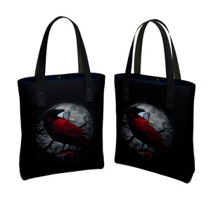 May include: Two black tote bags with red crow silhouettes on a moonlit background. The crows are perched on branches with a skull at the base of each tree.