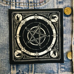 May include: Black and white square patch with a pentagram design. The patch features the words "YES", "NO", "MAYBE", and "UNKNOWN" around the edges. Decorative elements and a crescent moon are also included in the design.