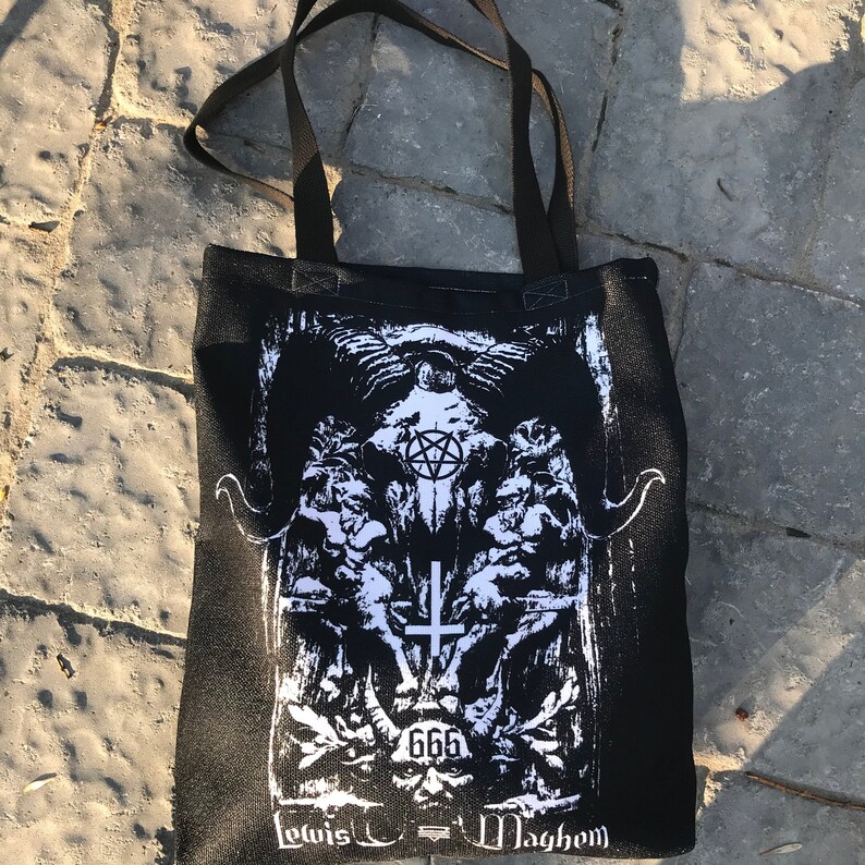 May include: Black tote bag with a white graphic print of a skull with horns, a pentagram, and a cross. The text "666" and "Lewis -  Maghem" are printed below the graphic.