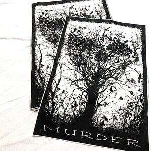 K&ouml;nnte beinhalten: Schwarz-wei&szlig; Patch mit einer gro&szlig;en Baum-Silhouette und vielen V&ouml;geln, die um ihn herum fliegen. Der Text "MURDER" ist am unteren Rand des Patches gedruckt.