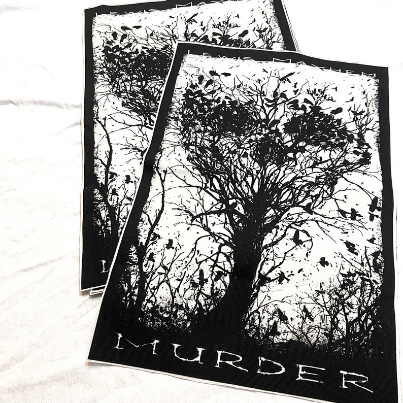K&ouml;nnte beinhalten: Schwarz-wei&szlig; Patch mit einer gro&szlig;en Baum-Silhouette und vielen V&ouml;geln, die um ihn herum fliegen. Der Text "MURDER" ist am unteren Rand des Patches gedruckt.