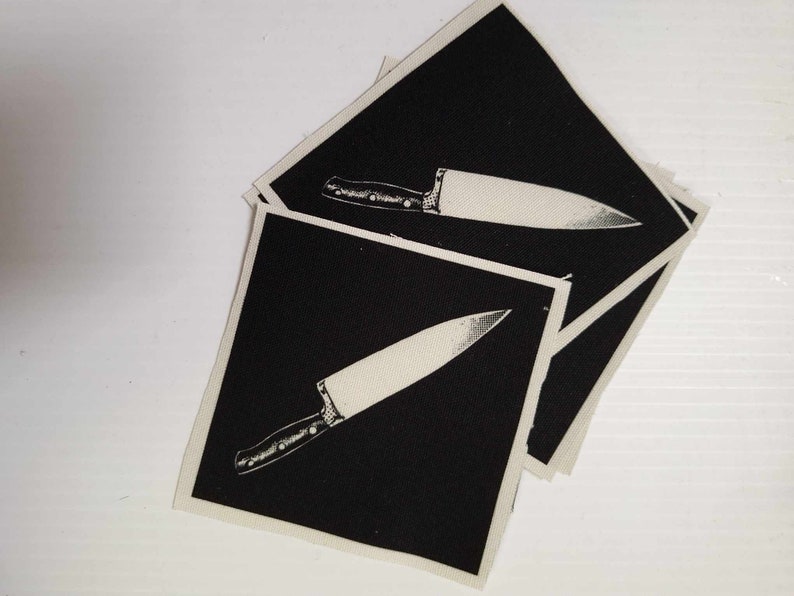 May include: Three black fabric patches with a white outline of a kitchen knife on each.