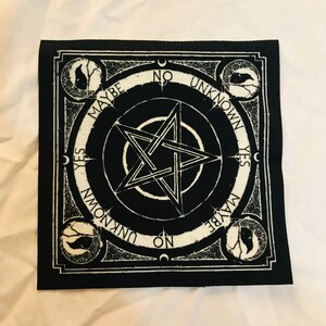 May include: Black and white square patch with a pentagram design at the center. The patch features the words "YES", "NO", "MAYBE", and "UNKNOWN" around the pentagram. Decorative elements include crescent moons and stylized tree and bird illustrations.
