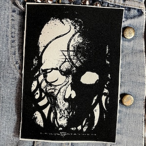 May include: Black and white embroidered patch with a skull-like image and the text "LEWIG MAYHEM".