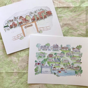 May include: Two watercolor prints of a community, one with a mountain backdrop and the other with a lake. The prints feature detailed illustrations of houses, trees, and a gate with the text "Sky Ranch". The artwork is on white paper.