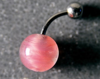 Peut inclure: Un piercing de nombril rose avec un motif en spirale. Le piercing est en métal et a une finition claire et brillante.