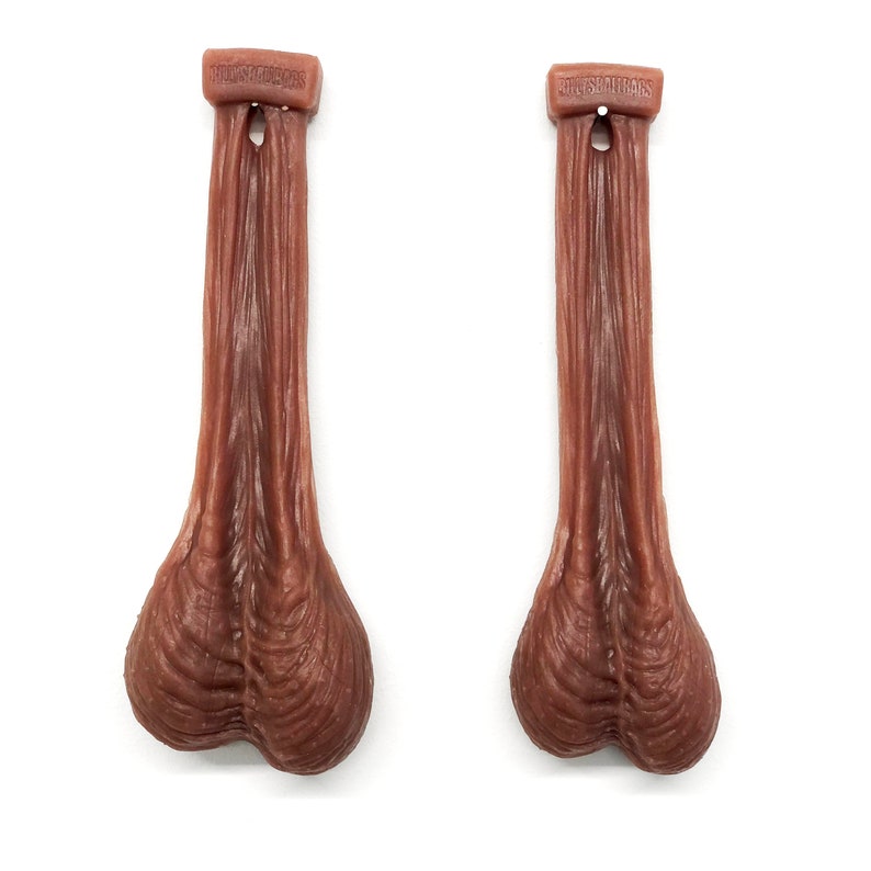 May include: Two brown rubber testicles with the text "HILLSIDE FARMERS" printed on the top of each.