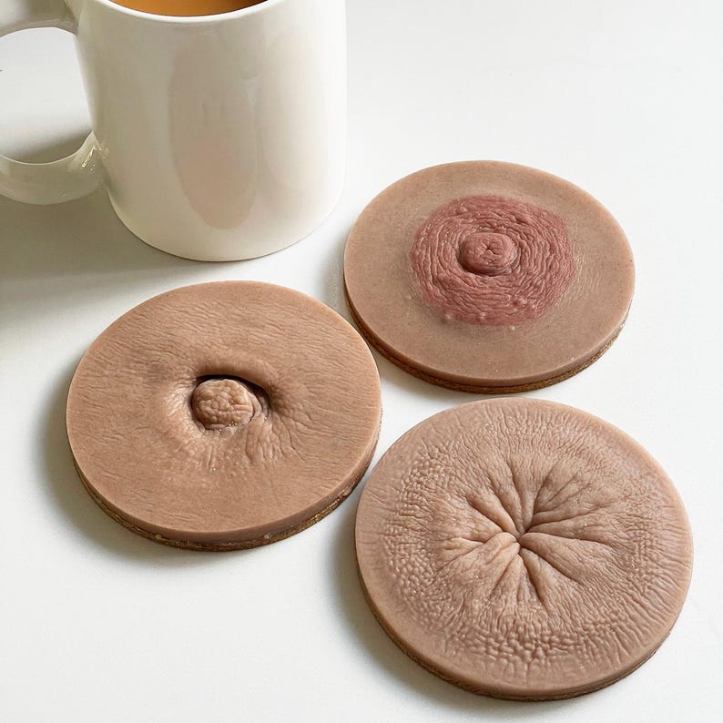 May include: Three round brown coasters with a raised nipple design. The coasters are made of a soft, fleshy material.