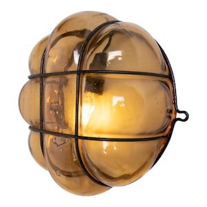 May include: A brown glass globe light fixture with a black metal cage. The globe is made of multiple rounded sections and has a light bulb inside.
