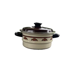 May include: A cream-colored enamel pot with a dark brown lid and matching side handles. The exterior features a horizontal band with a repeating floral pattern in red, orange, and green. The pot has a metallic rim and a rounded, lidded design.