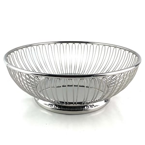 May include: A silver wire fruit bowl with a round base. The bowl is made of thin wire and has a decorative design.