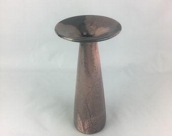 May include: A black and brown ceramic vase with a wide, flared opening and a narrow, cylindrical base.