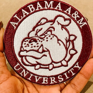May include: A maroon and white embroidered patch with the words "Alabama A&M University" surrounding a white bulldog mascot.