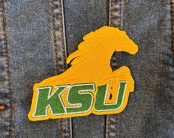 May include: A green and yellow embroidered patch with a horse and the letters "KSU".