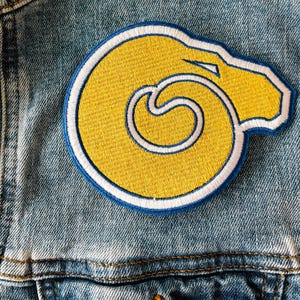 May include: A blue denim jacket with a yellow and white embroidered ram's head patch.