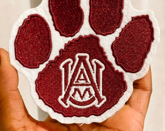 May include: A maroon paw print patch with a white "A&M" embroidered in the center.