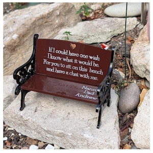 May include: A miniature brown bench with black scrollwork sides and a small red bird figurine on the top right. The backrest features the engraved text: If I could have one wish I know what it would be. For you to sit on this bench and have a chat with me. The seat includes the names Nanny, Dad, and Andrew.