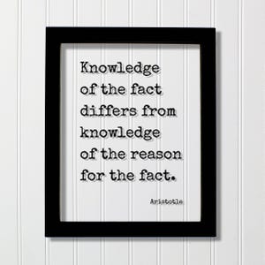 May include: A rectangular black frame containing a white print with the black typewriter-style text: Knowledge of the fact differs from knowledge of the reason for the fact. The name Aristotle is printed in the bottom right corner of the white paper.