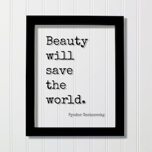 May include: A black rectangular frame containing a white print with the black typewriter-style text: Beauty will save the world. The name Fyodor Dostoevsky is printed in a smaller font at the bottom right corner of the white paper insert.
