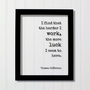 May include: A black rectangular frame containing a white background with black typewriter-style text that reads: I find that the harder I work, the more luck I seem to have. Thomas Jefferson. The quote is centered within the frame.