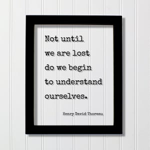 Op de afbeelding: Een zwarte rechthoekige lijst met een witte print met de zwarte tekst in typemachinestijl: Not until we are lost do we begin to understand ourselves. De naam Henry David Thoreau staat in kleinere zwarte letters rechtsonder.