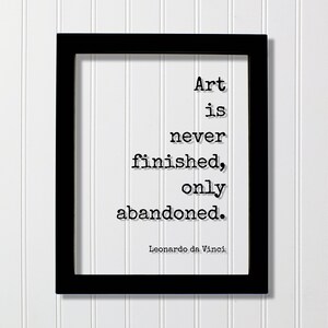 May include: Black framed print with a white background and black text that reads "Art is never finished, only abandoned."  The text is attributed to Leonardo da Vinci.
