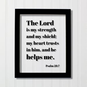 May include: A black rectangular frame containing a white background with the black text: The Lord is my strength and my shield; my heart trusts in him, and he helps me. Psalm 28:7. The lettering features a subtle drop shadow effect.