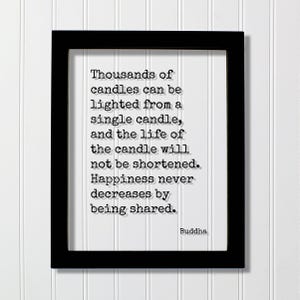 May include: A black rectangular frame containing a white print with the black typewriter-style text: Thousands of candles can be lighted from a single candle, and the life of the candle will not be shortened. Happiness never decreases by being shared. Buddha.