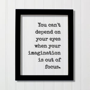 以下が含まれることがあります： 黒い長方形のフォトフレーム。白い台紙には「You can't depend on your eyes when your imagination is out of focus.」という黒い文字が印字されています。文字はタイプライター風のフォントで、かすかなドロップシャドウ効果が施されています。