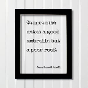 May include: A black rectangular frame containing a white print with the black typewriter-style text: Compromise makes a good umbrella but a poor roof. The author name James Russell Lowell is printed in smaller black text at the bottom right corner.