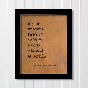 May include: A rectangular black frame containing a tan, textured background with the black printed text: A room without books is like a body without a soul. Marcus Tullius Cicero. The quote is presented in a typewriter-style font on a leather-like surface.