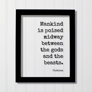 May include: A black rectangular frame containing a white background with black typewriter-style text that reads: Mankind is poised midway between the gods and the beasts. Plotinus. The lettering features a subtle drop shadow effect on the white surface.