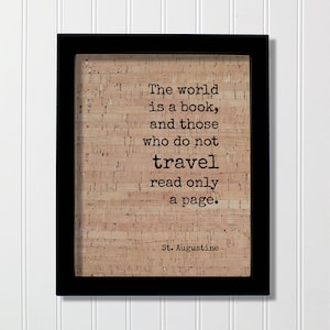 Könnte beinhalten: Ein rechteckiger schwarzer Rahmen mit einem hellbraunen Korkhintergrund und dem schwarz aufgedruckten Text: The world is a book, and those who do not travel read only a page. St. Augustine. Der Kork hat eine natürliche, texturierte Optik.