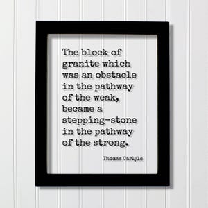 May include: A black rectangular frame containing a white print with the black text: The block of granite which was an obstacle in the pathway of the weak, became a stepping-stone in the pathway of the strong. The author is Thomas Carlyle.