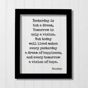 May include: Black framed print with a white background and a quote in black text: "Yesterday is but a dream, Tomorrow is only a vision. But today well lived makes every yesterday a dream of happiness, and every tomorrow a vision of hope." The quote is attributed to Kālidāsa.