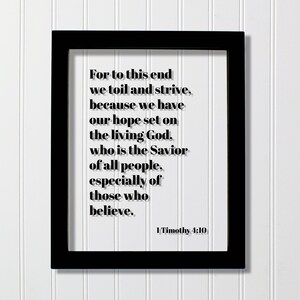 May include: Black framed print with a white background and black text. The text reads "For to this end we toil and strive, because we have our hope set on the living God, who is the Savior of all people, especially of those who believe." The text is followed by "1 Timothy 4:10".