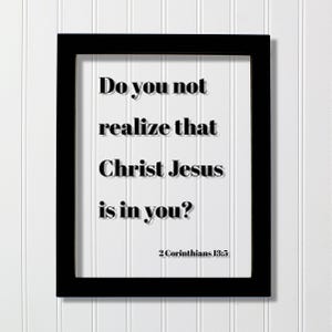 Può includere: Una cornice nera rettangolare contenente uno sfondo bianco con il testo nero: Do you not realize that Christ Jesus is in you? 2 Corinthians 13:5. Le scritte presentano un sottile effetto ombra, creando un aspetto stratificato all'interno della cornice.