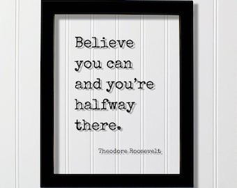 May include: A black rectangular frame containing a white print with the black typewriter-style text: Believe you can and you're halfway there. The name Theodore Roosevelt is printed in smaller black text at the bottom right of the white area.