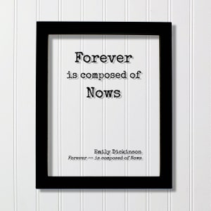 May include: Black framed print with a white background and the text "Forever is composed of Nows" in black typewriter font. The text "Emily Dickinson" and "Forever - is composed of Nows" are also in black typewriter font.