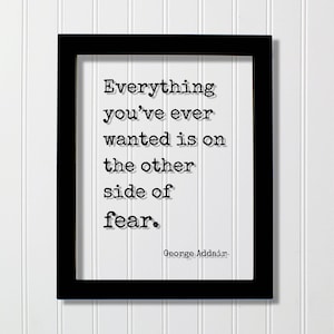 Puede incluir: Un marco rectangular negro que contiene una impresión blanca con el texto negro estilo máquina de escribir: Everything you've ever wanted is on the other side of fear. George Addair. Las letras presentan un sutil efecto de sombra.