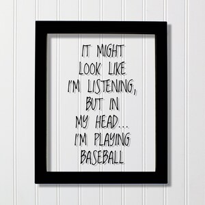 Puede incluir: Impresión enmarcada en negro con fondo blanco y texto negro que dice "IT MIGHT LOOK LIKE I'M LISTENING, BUT IN MY HEAD... I'M PLAYING BASEBALL".