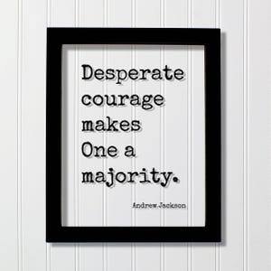 Op de afbeelding: Een zwarte rechthoekige lijst met een witte print met de zwarte tekst in typemachinestijl: Desperate courage makes One a majority. De naam Andrew Jackson staat in kleinere zwarte letters in de rechterbenedenhoek van het witte papier.