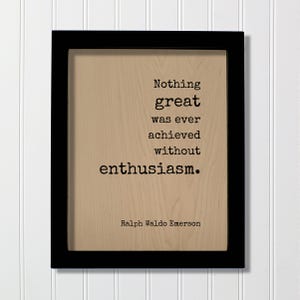 May include: A rectangular black frame containing a light wood-toned panel with the black printed text: Nothing great was ever achieved without enthusiasm. Ralph Waldo Emerson. The lettering is in a typewriter-style font centered on the wood surface.